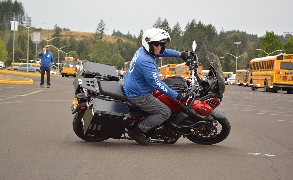 Team Oregon rider making a turn in a parking lot while an instructor watches