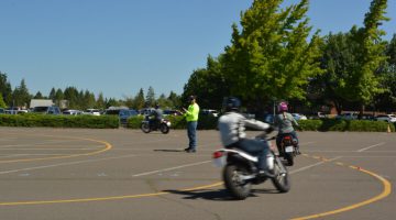 motorcyclists practicing riding in parking lot