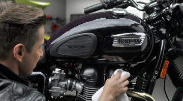 Man cleaning Triumph Motorcycle