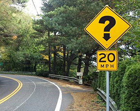 Turn sign with a question mark on a curve